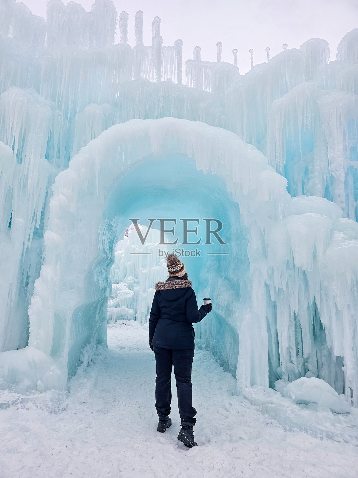 一个人在冰冻的冬季景观中穿过冰冷的拱门照片摄影图片