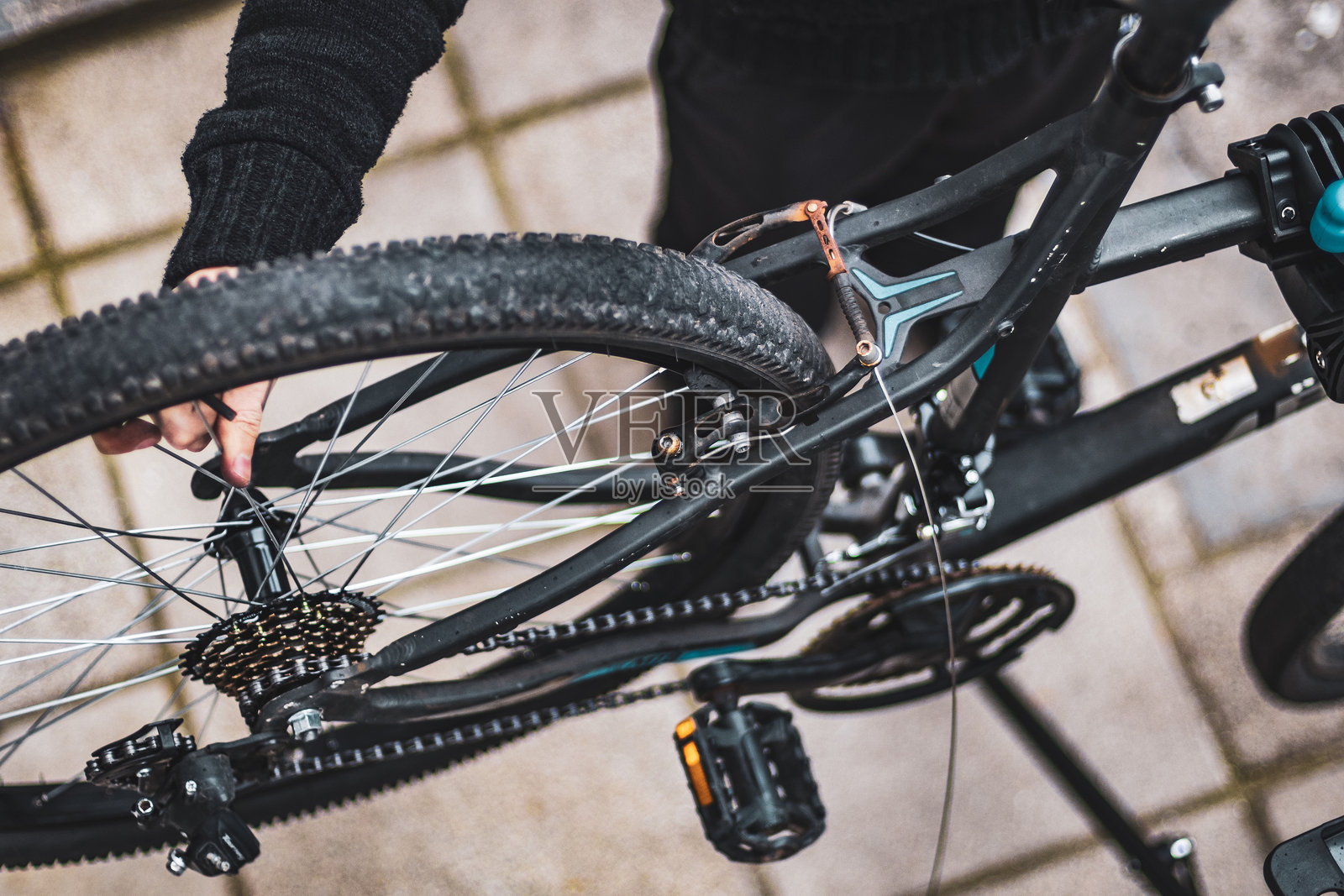 一个年轻人在房子的后院修理自行车。照片摄影图片