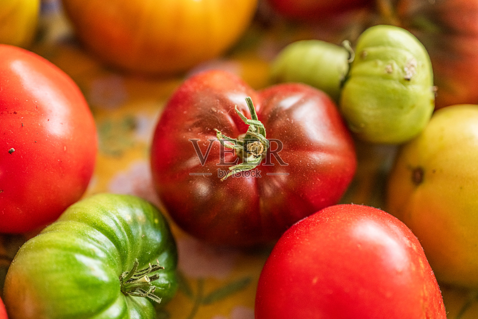 五颜六色的番茄和辣椒摆放在桌子上。照片摄影图片