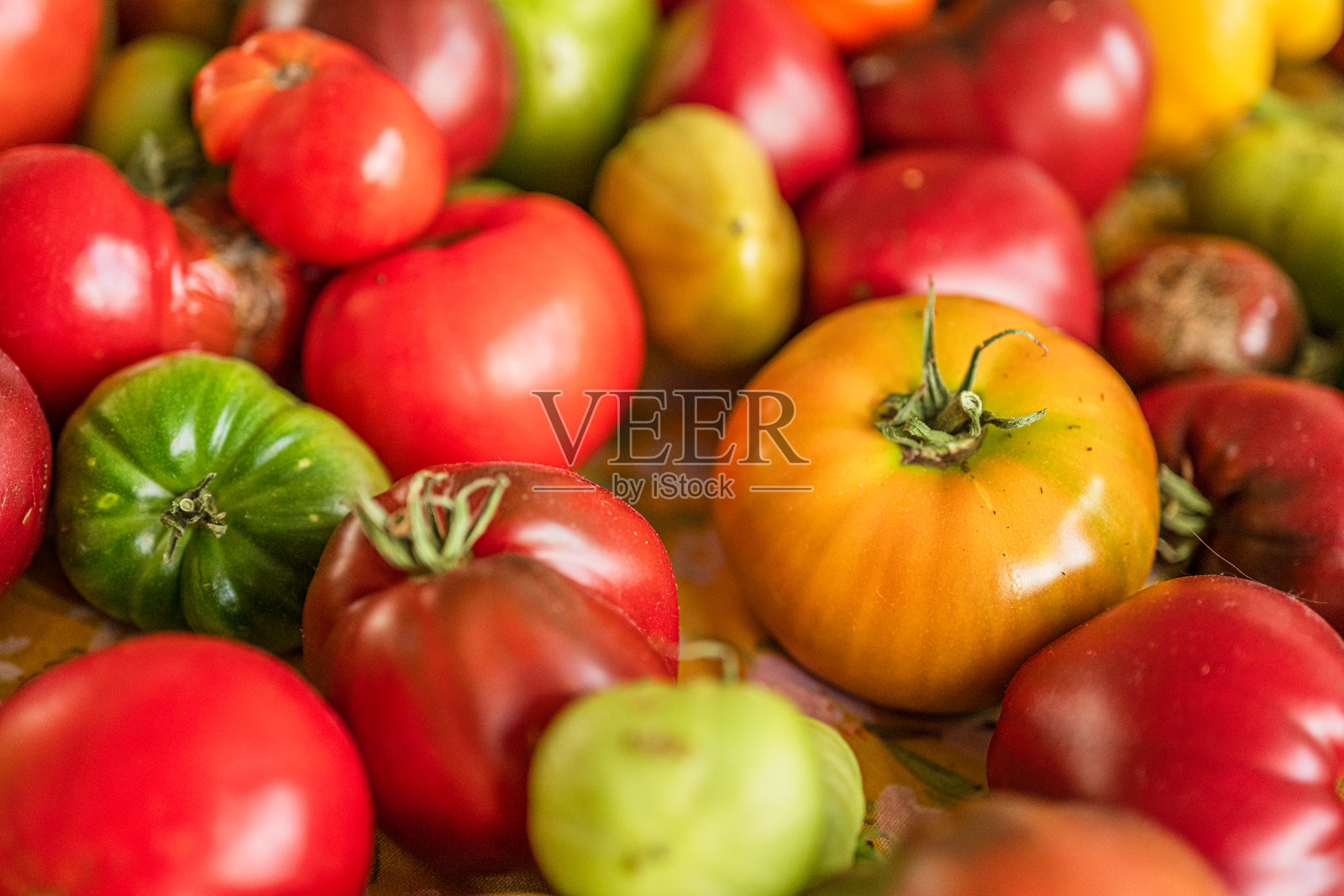 五颜六色的番茄和辣椒在桌子上摆放。照片摄影图片