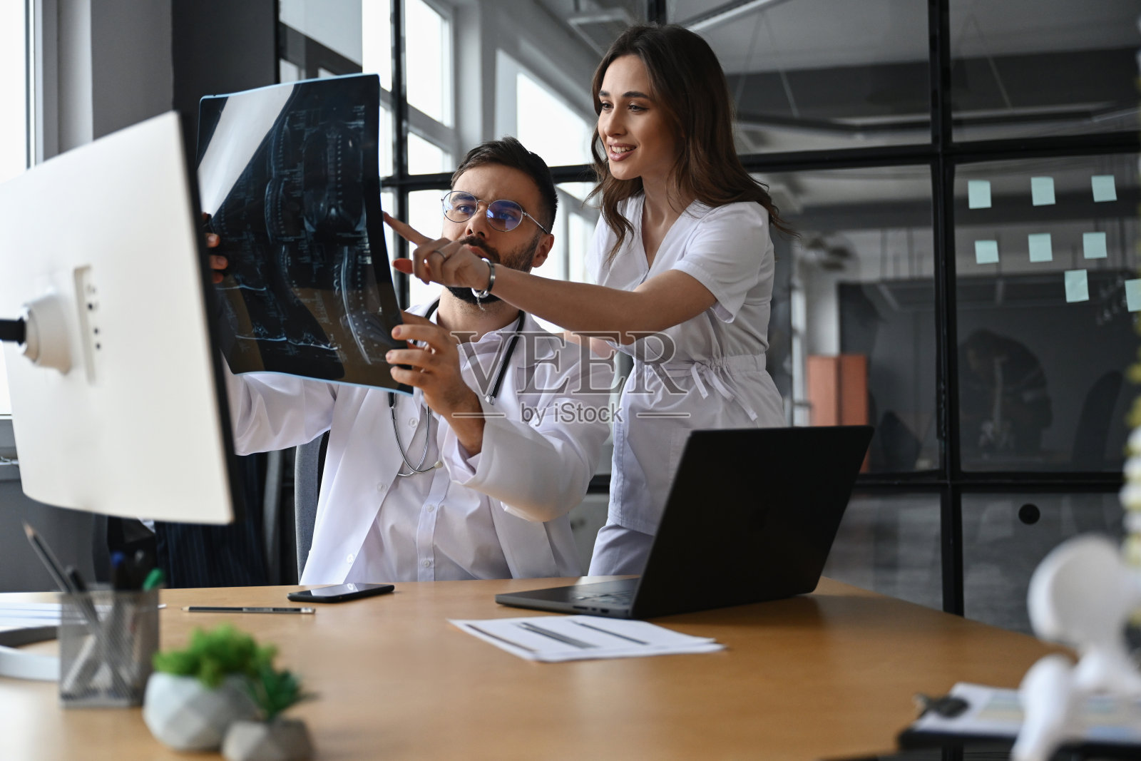 医生在办公室查看X光片进行诊断。照片摄影图片