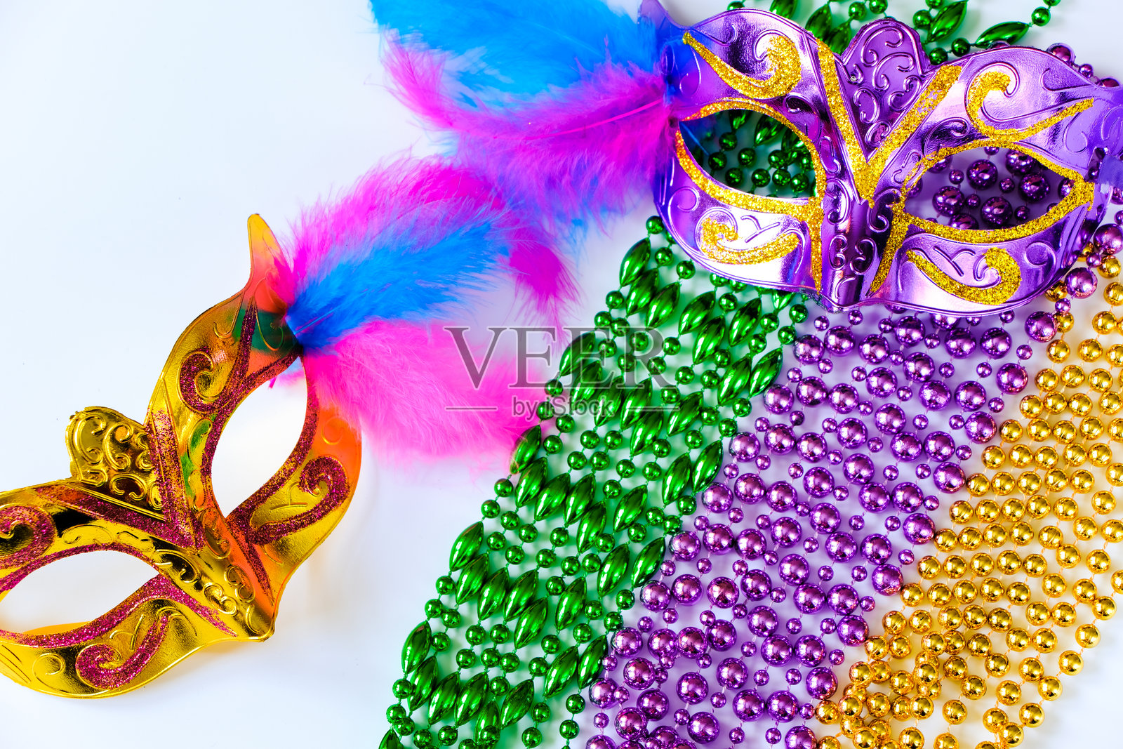 两面带羽毛和多彩珠子的嘉年华面具，背景为白色。狂欢节或肥胖星期二的象征。照片摄影图片