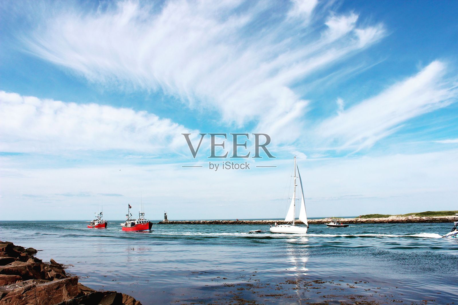 平静海面上的帆船和渔船照片摄影图片