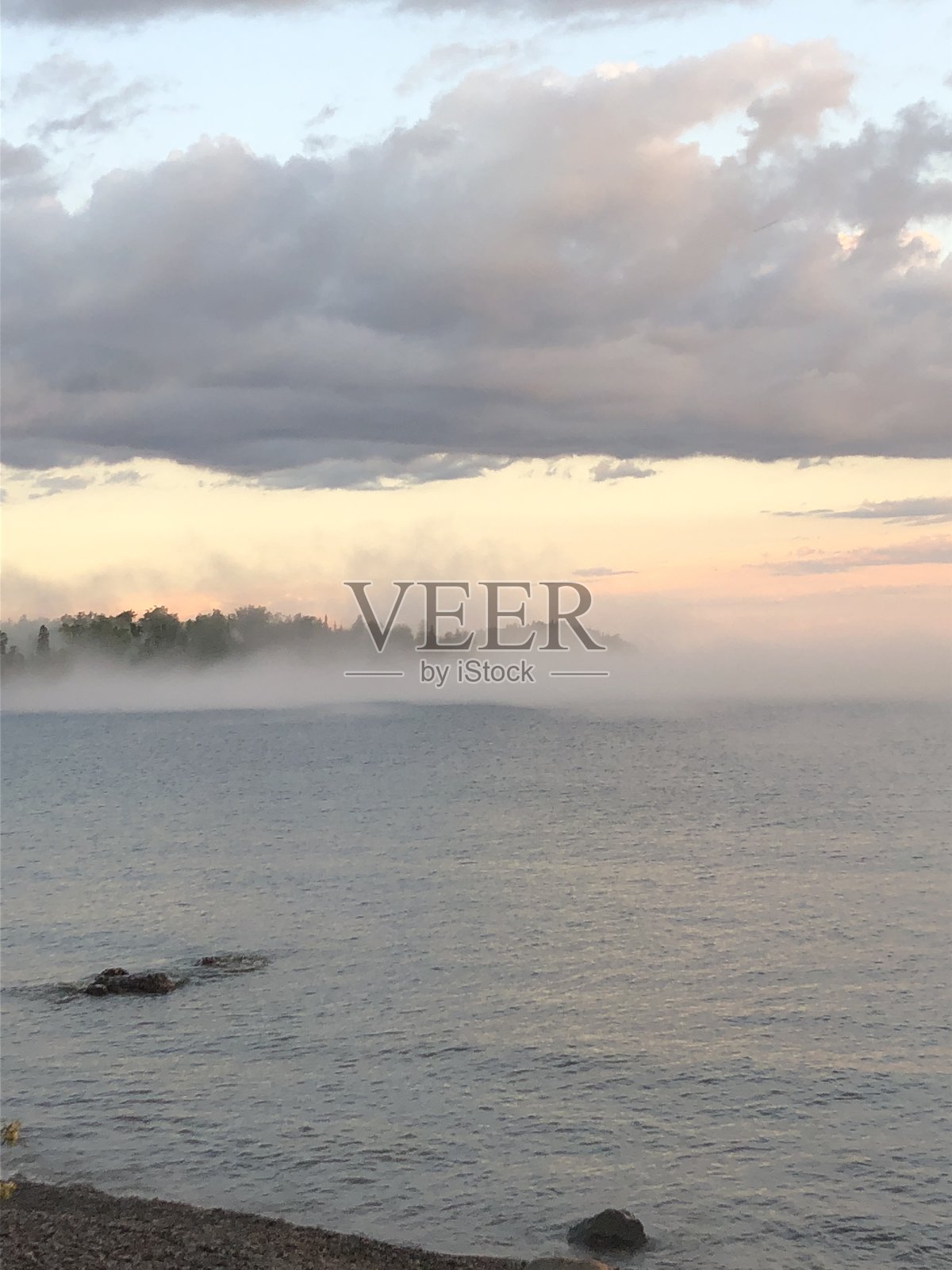 雾气在多云的傍晚笼罩着苏必利尔湖照片摄影图片