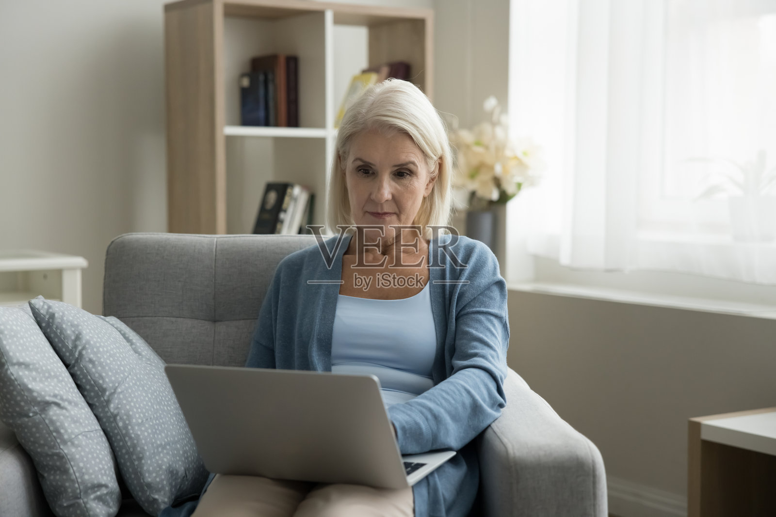 成熟的女性在家中放松，使用无线网络和笔记本电脑照片摄影图片