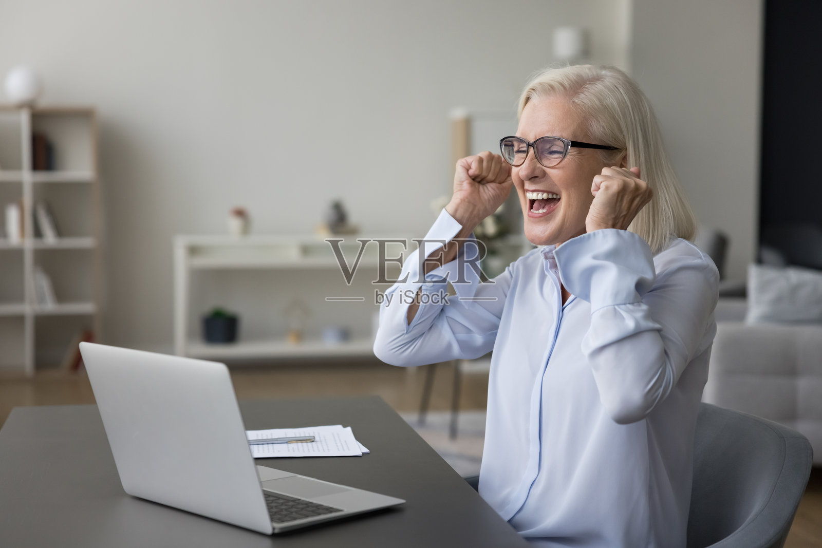 快乐的老年女性在阅读电子邮件中的好消息照片摄影图片