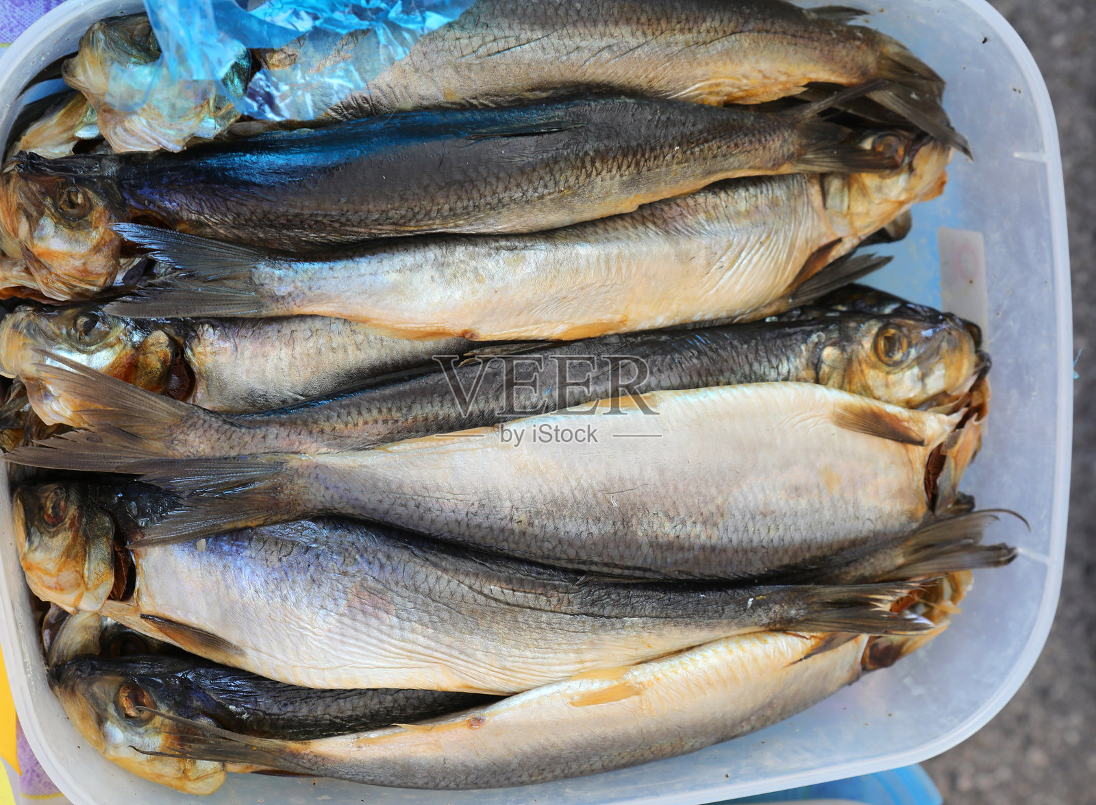 许多用盐腌制的生鱼在摊位上的塑料托盘中出售照片摄影图片