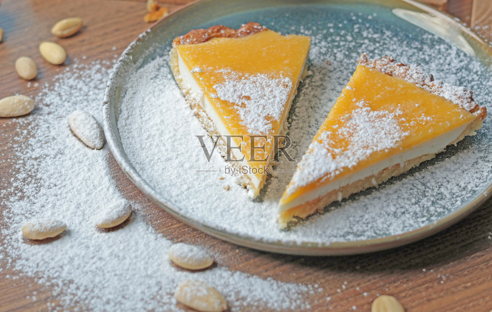 厨房里放着一盘杏仁粉和天然水果的蛋糕块。桌子上有坚果。健康食品和产品。照片摄影图片