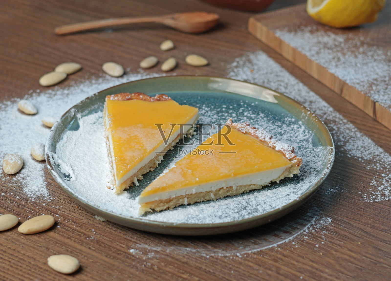 厨房里放着一盘杏仁粉和天然水果的蛋糕块。桌子上有坚果。健康食品和产品。照片摄影图片