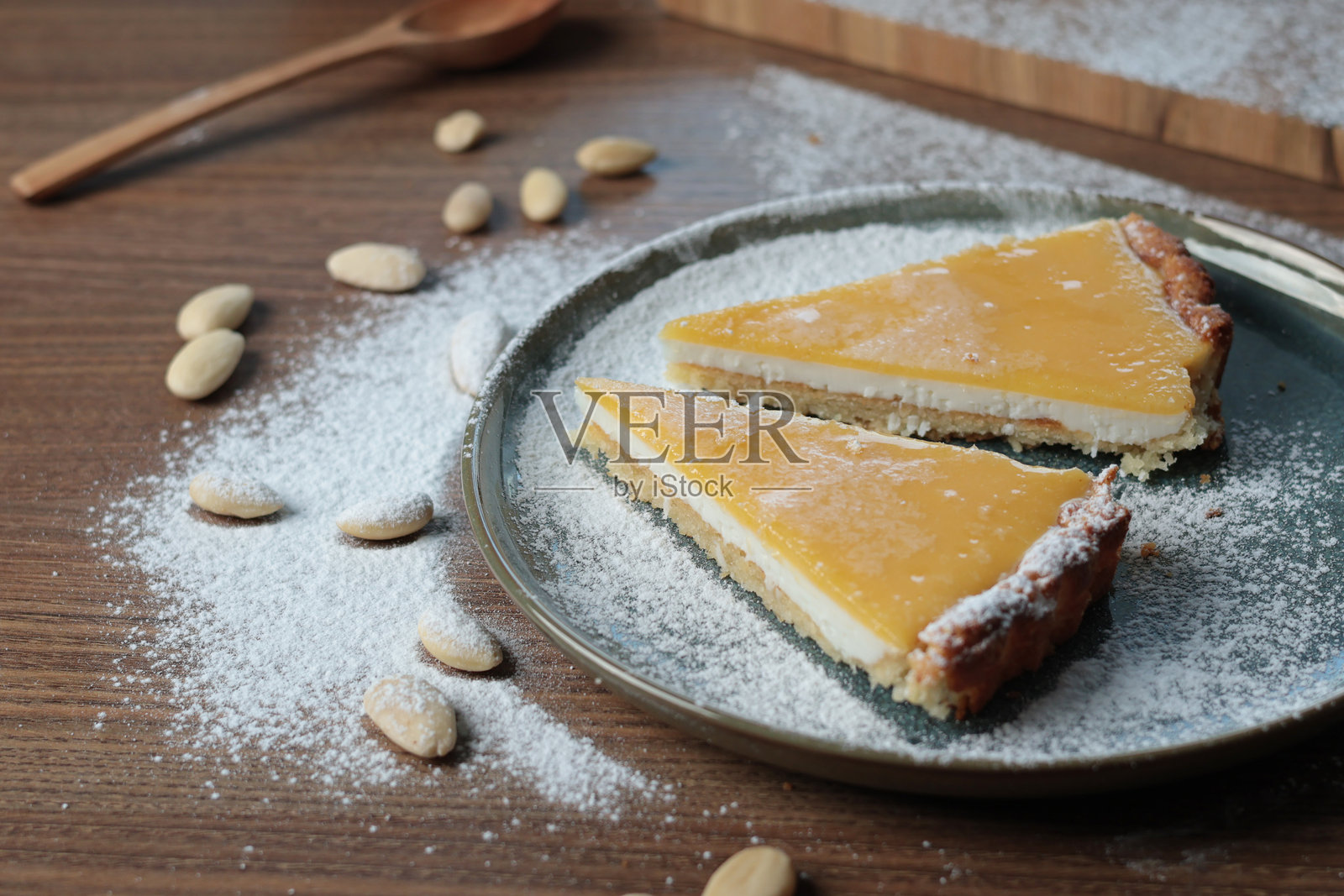 厨房里杏仁粉和天然水果的盘子上的蛋糕块。桌子上的坚果。健康食品和产品。照片摄影图片