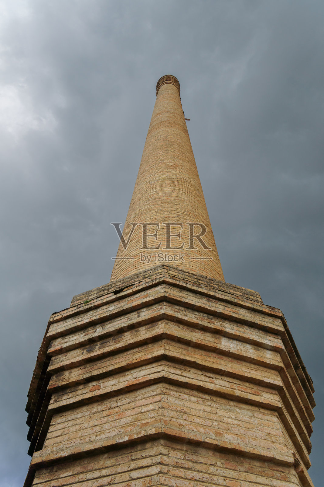 古老的砖厂烟囱与戏剧性的多云天空照片摄影图片