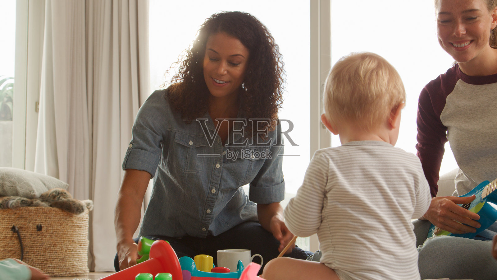 两位母亲带着幼儿在家中见面进行游戏约会的特写镜头照片摄影图片