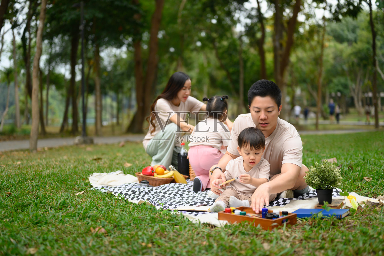 慈爱的父亲在公园的野餐中教小孩画画照片摄影图片