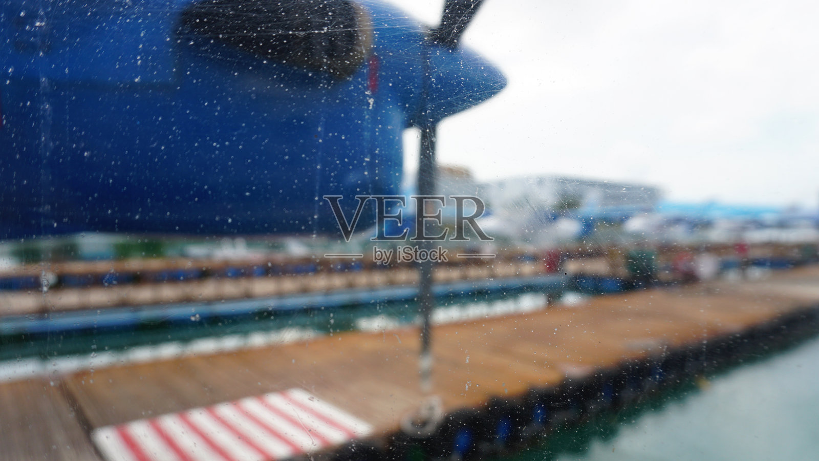 飞机窗户上的雨滴，俯瞰热带度假村码头照片摄影图片