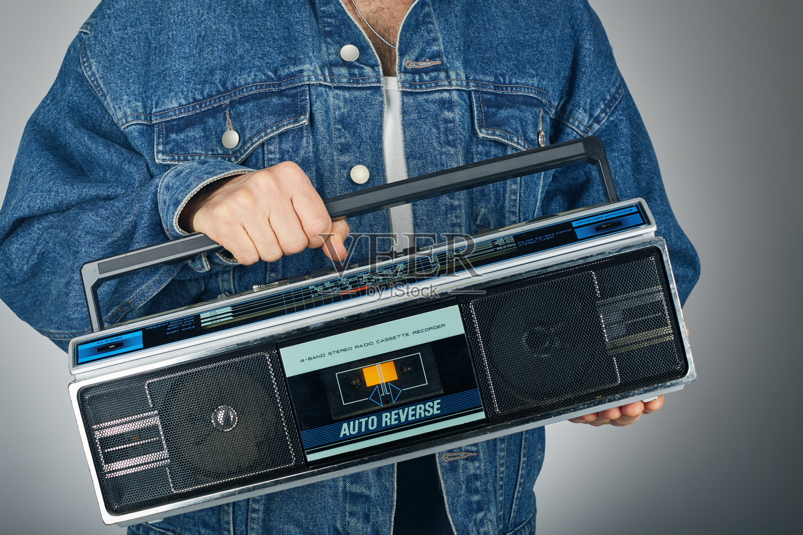 复古男士穿着牛仔服，手持收音机音响盒式录音机照片摄影图片