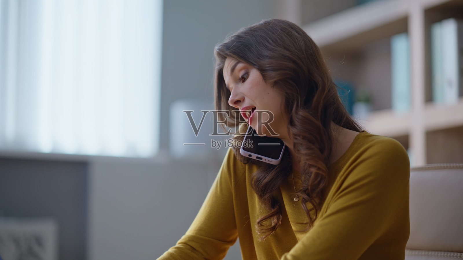 办公室工作人员在企业空间中微笑着打电话并在笔记本电脑上输入文字的特写镜头。照片摄影图片