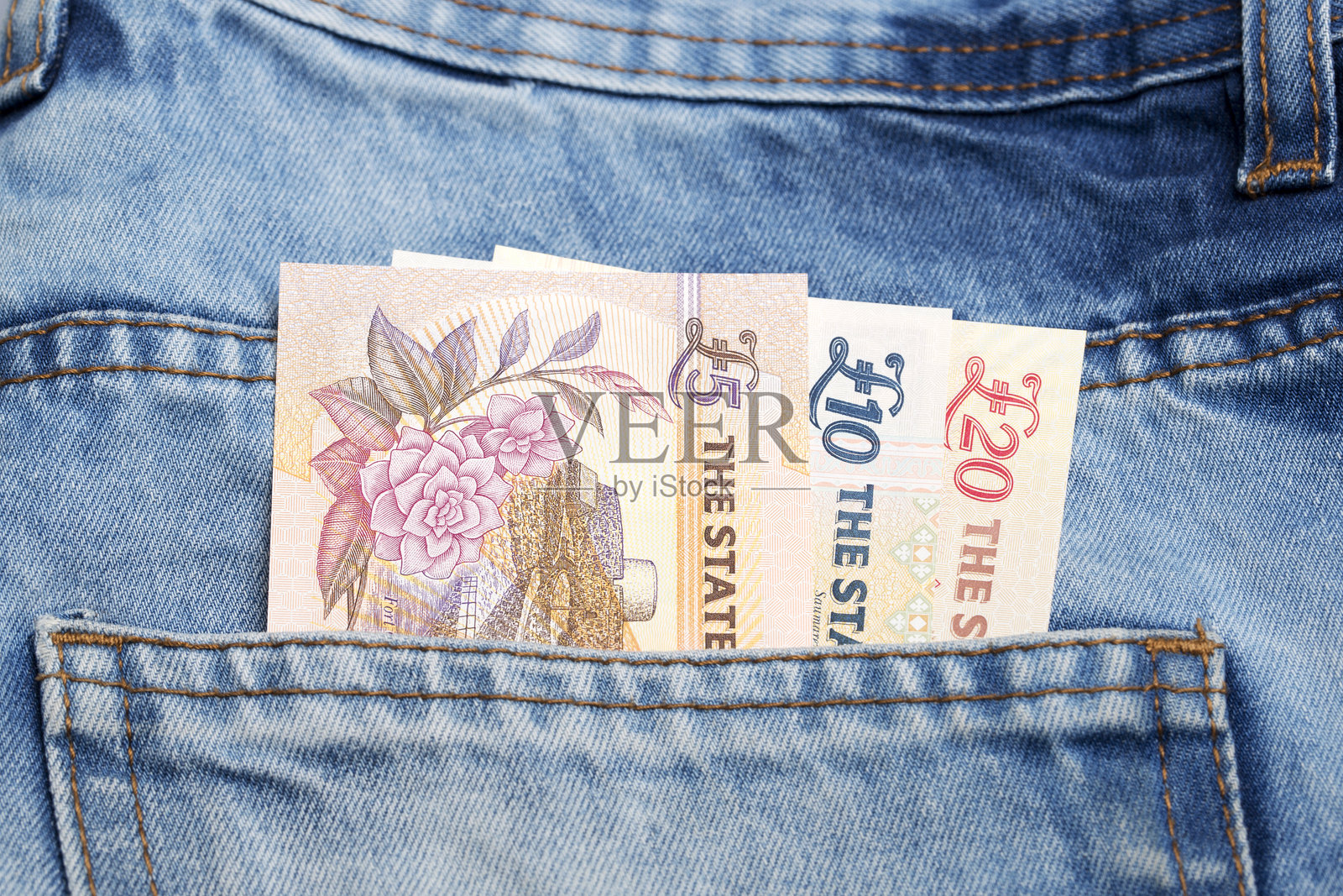 蓝色牛仔裤口袋里的根西镑照片摄影图片