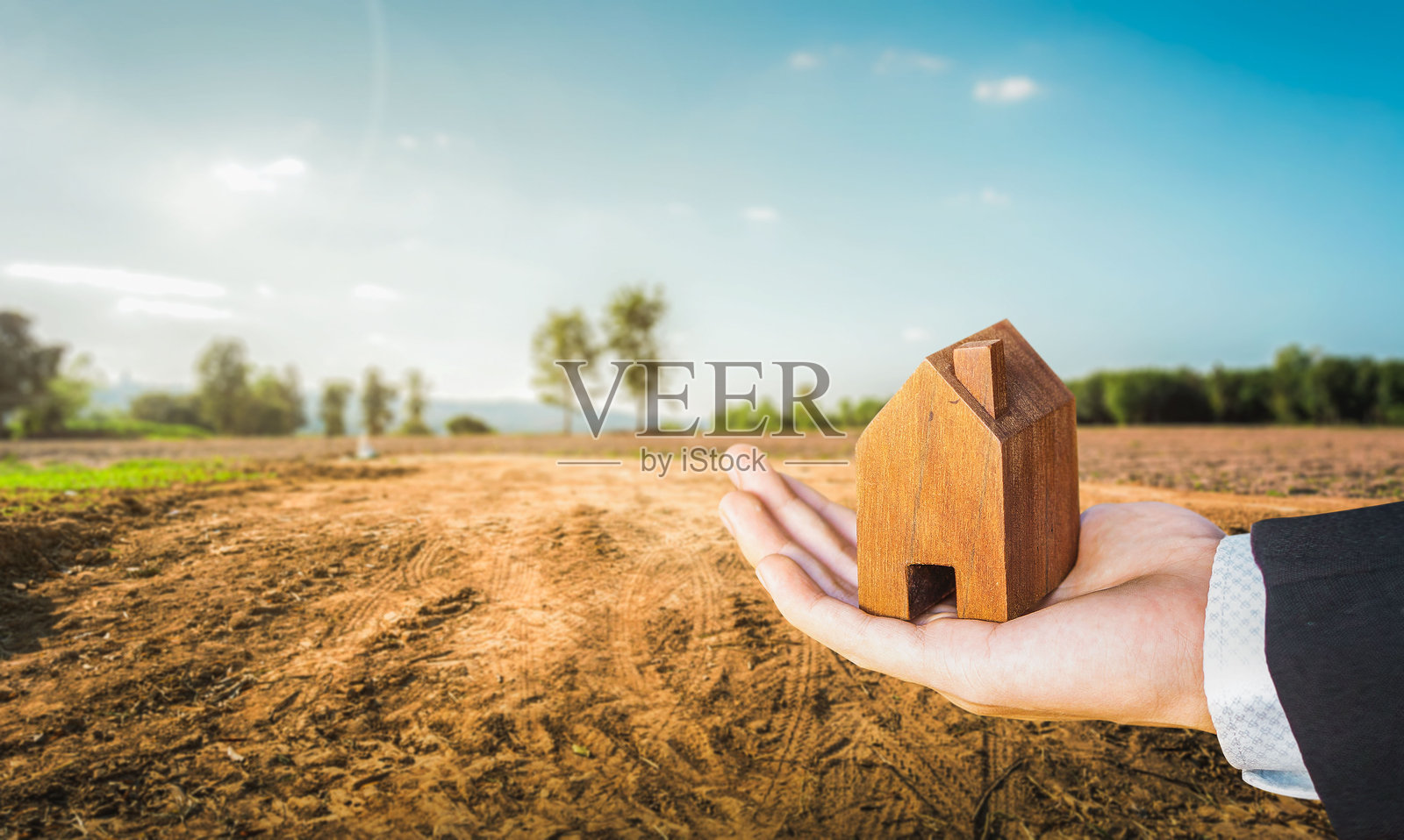 房屋符号与位置图钉在空旷干裂的沼泽复垦土壤上，适合住房建设项目的土地，房地产投资概念，为家庭购买新家。照片摄影图片