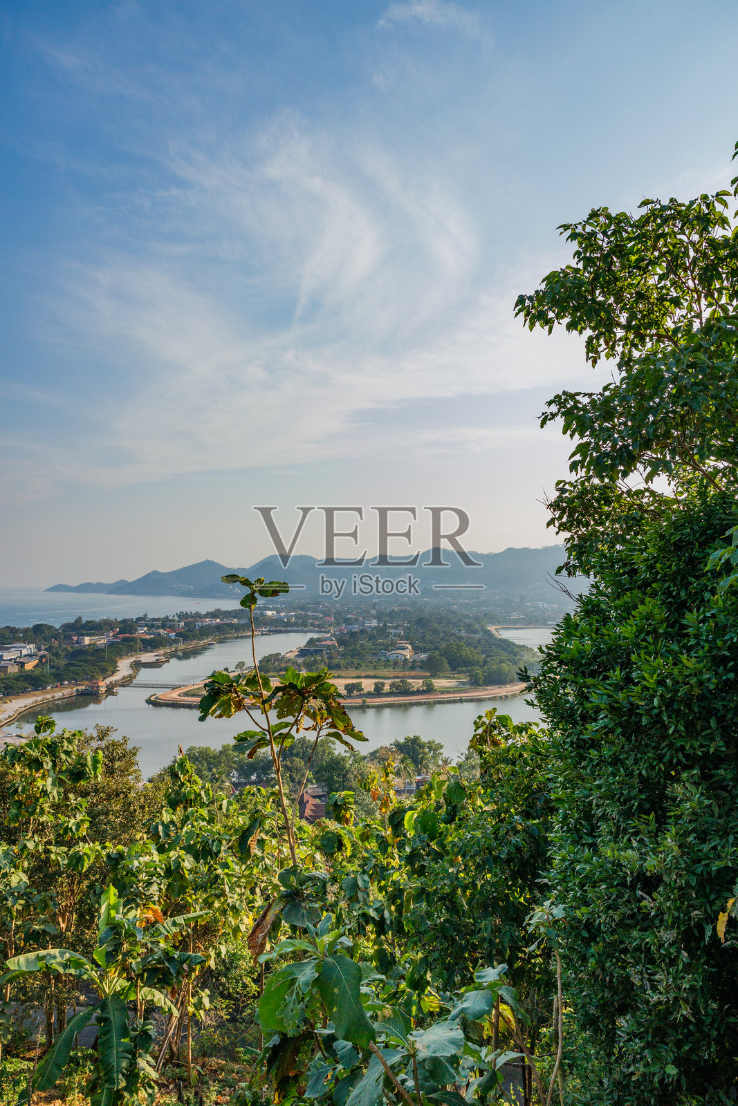 从考华祝塔俯瞰热带植被，俯瞰查汶湖和苏梅岛的海岸线，山脉在轻柔的云朵下延伸至地平线。照片摄影图片