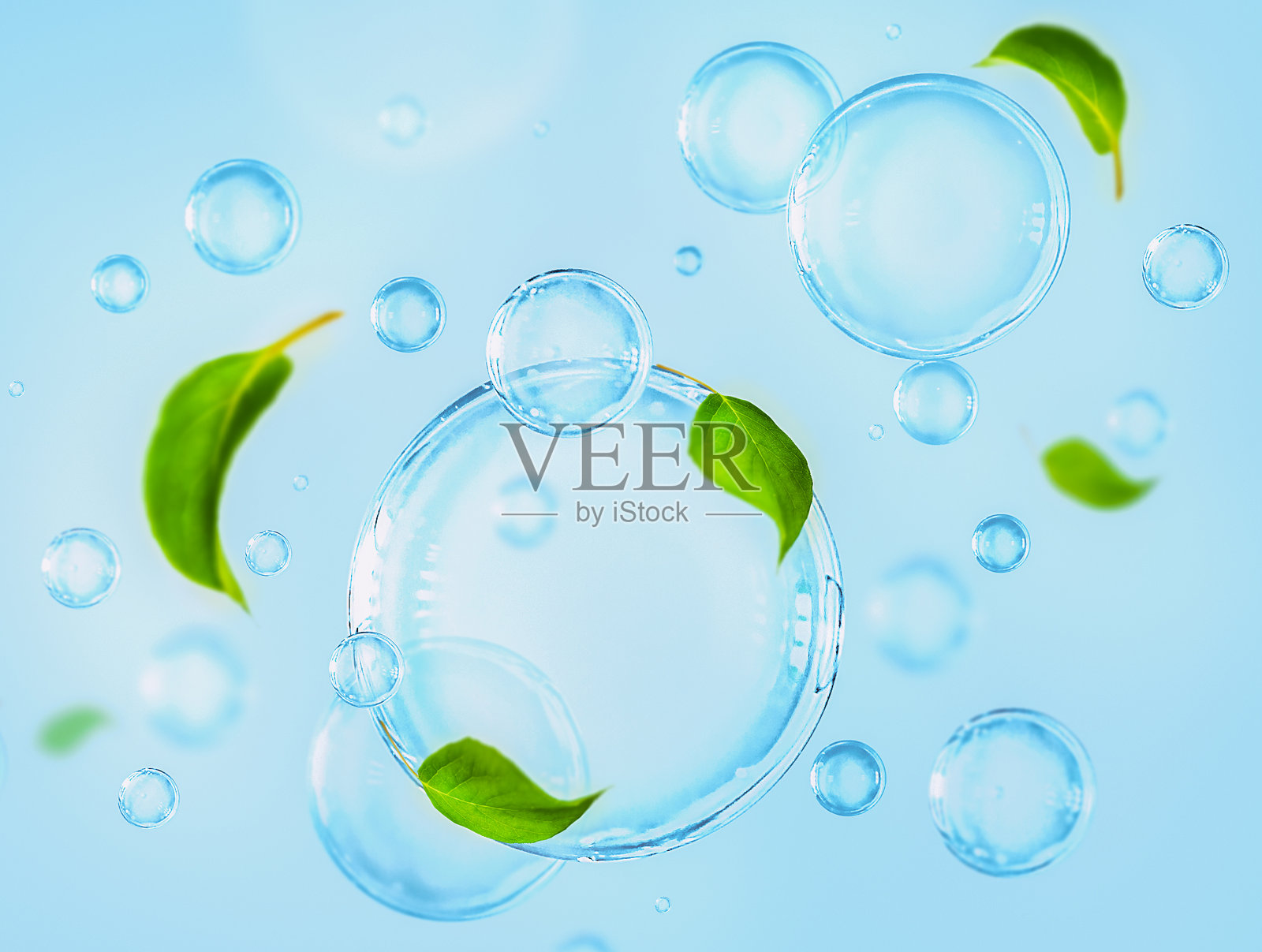 蓝色背景上描绘了带有绿色叶子的气泡，体现了卫生和环保的概念。照片摄影图片