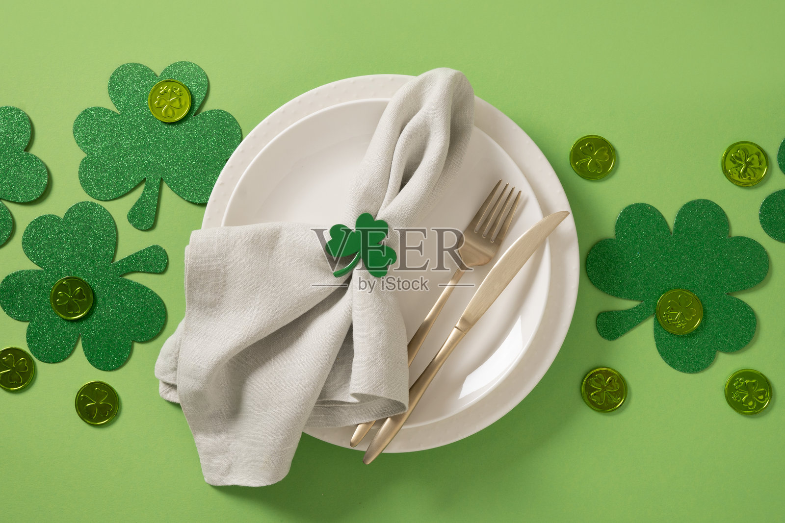 圣帕特里克节派对桌面布置，绿色装饰与绿色背景相映成趣。照片摄影图片