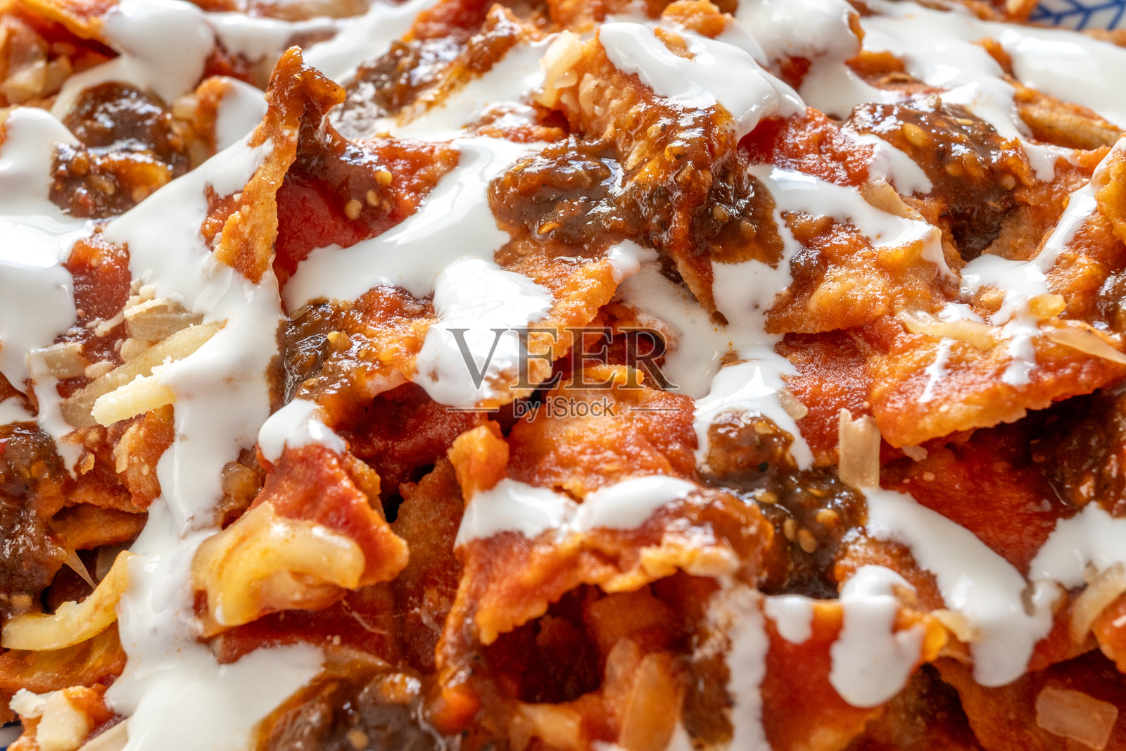 红绿酱的奇拉基莱，配有新鲜奶酪和奶油，覆盖在玉米片上照片摄影图片