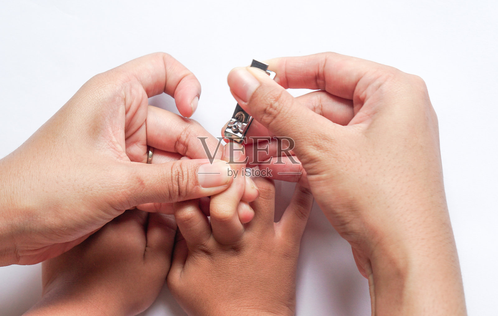 特写母亲的手握着指甲剪为婴儿修剪小手指的指甲。幼儿的手。用爱与关怀保持干净，体现父母和母亲的角色。照片摄影图片