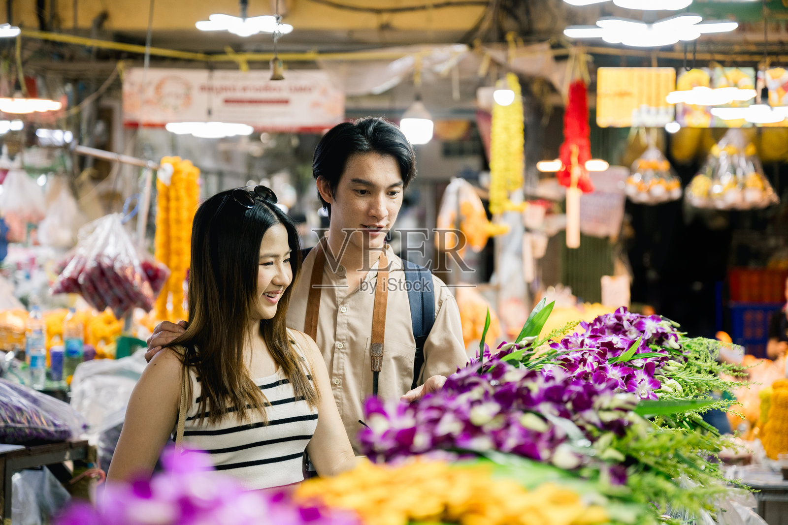 年轻游客情侣在曼谷的帕克隆塔拉特挑选鲜花照片摄影图片