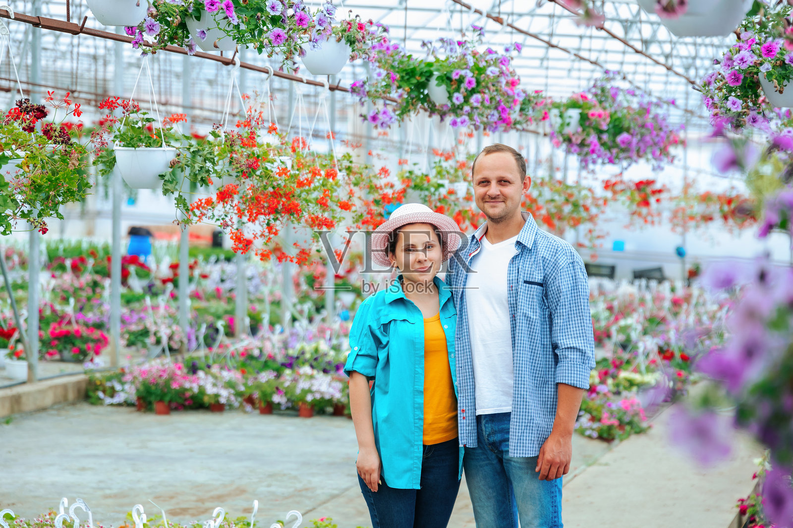 一家有志于成为花卉销售商的家庭站在温室里，随后转身看向镜头。照片摄影图片