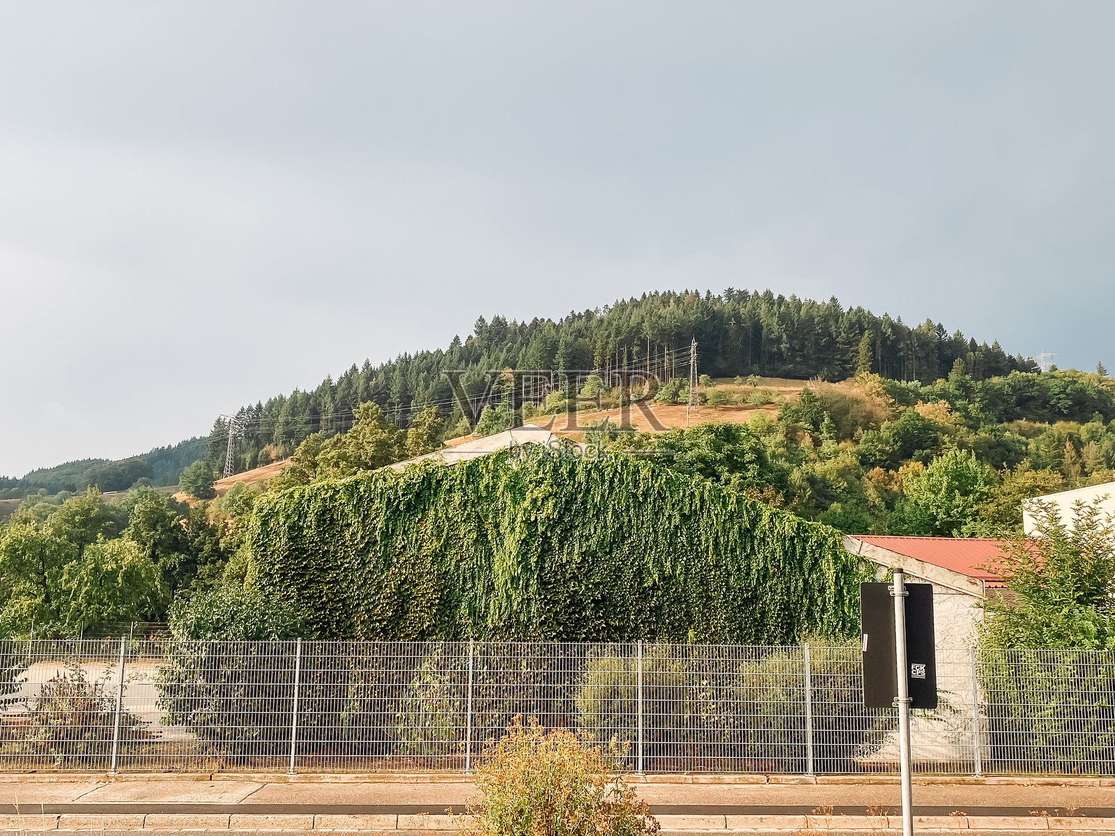围绕山上房子的栅栏照片摄影图片