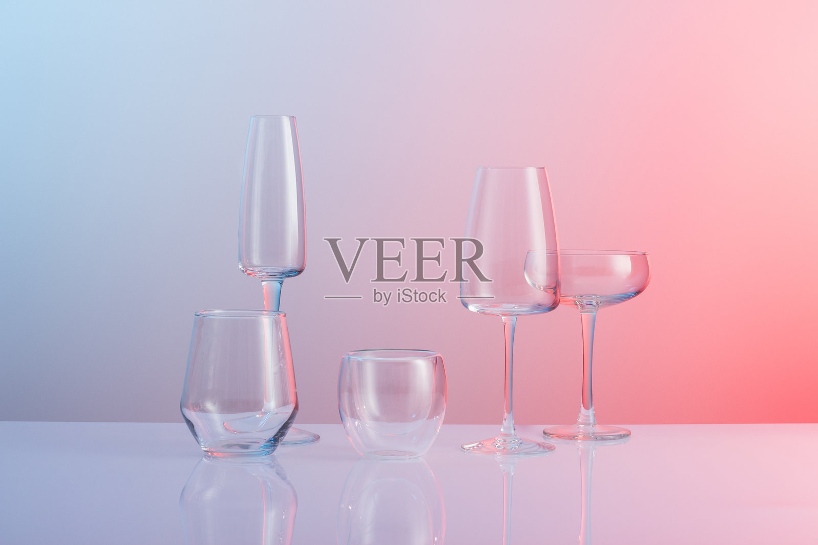 粉色和蓝色渐变背景上的玻璃器皿照片摄影图片