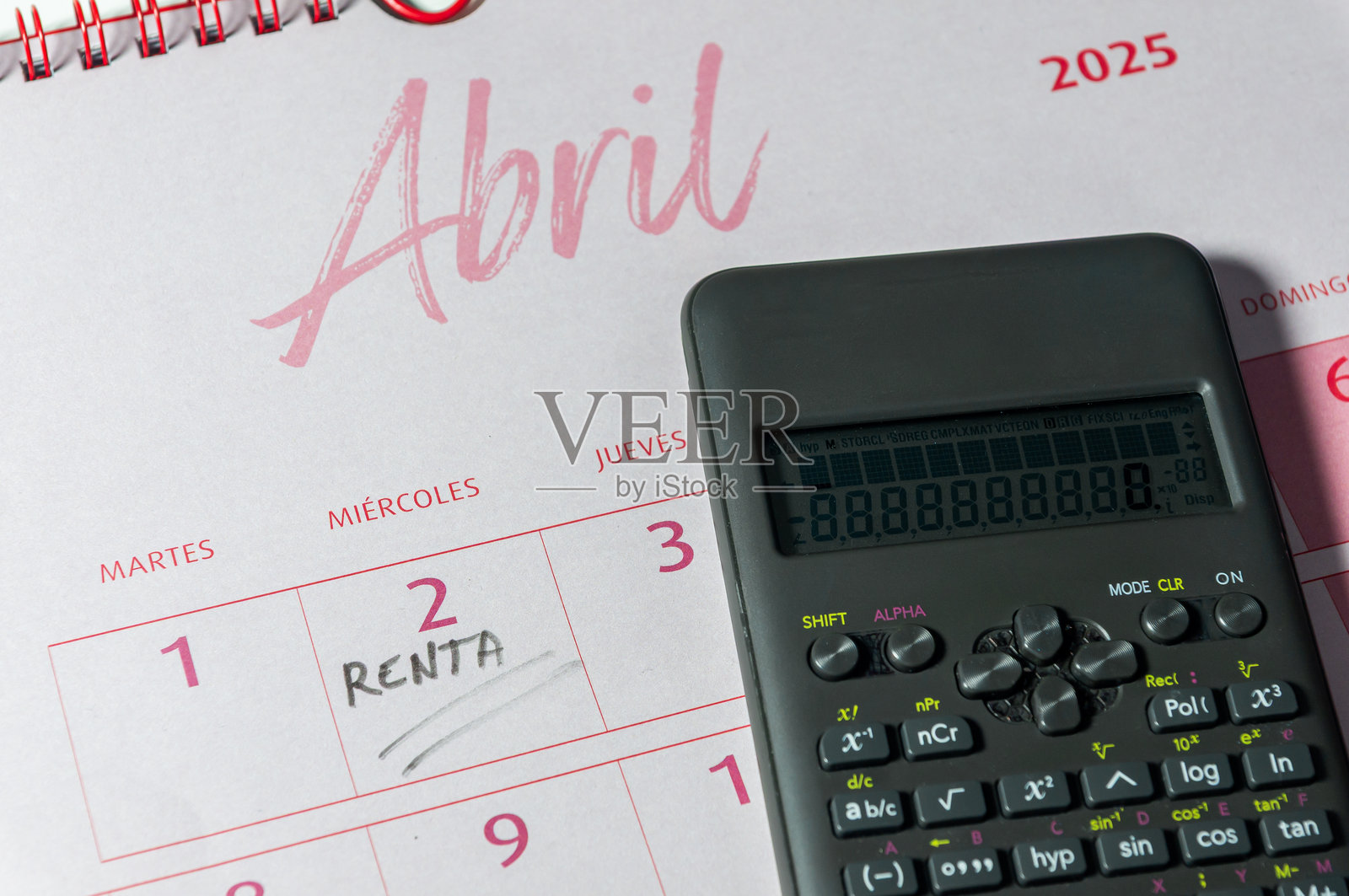 2025年报税活动：四月日历一瞥，第二天被标记，旁边放着一台计算器。照片摄影图片