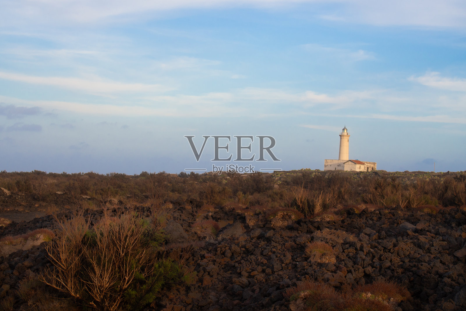 西西里岛利诺萨岛的孤独灯塔，周围环绕着火山景观照片摄影图片