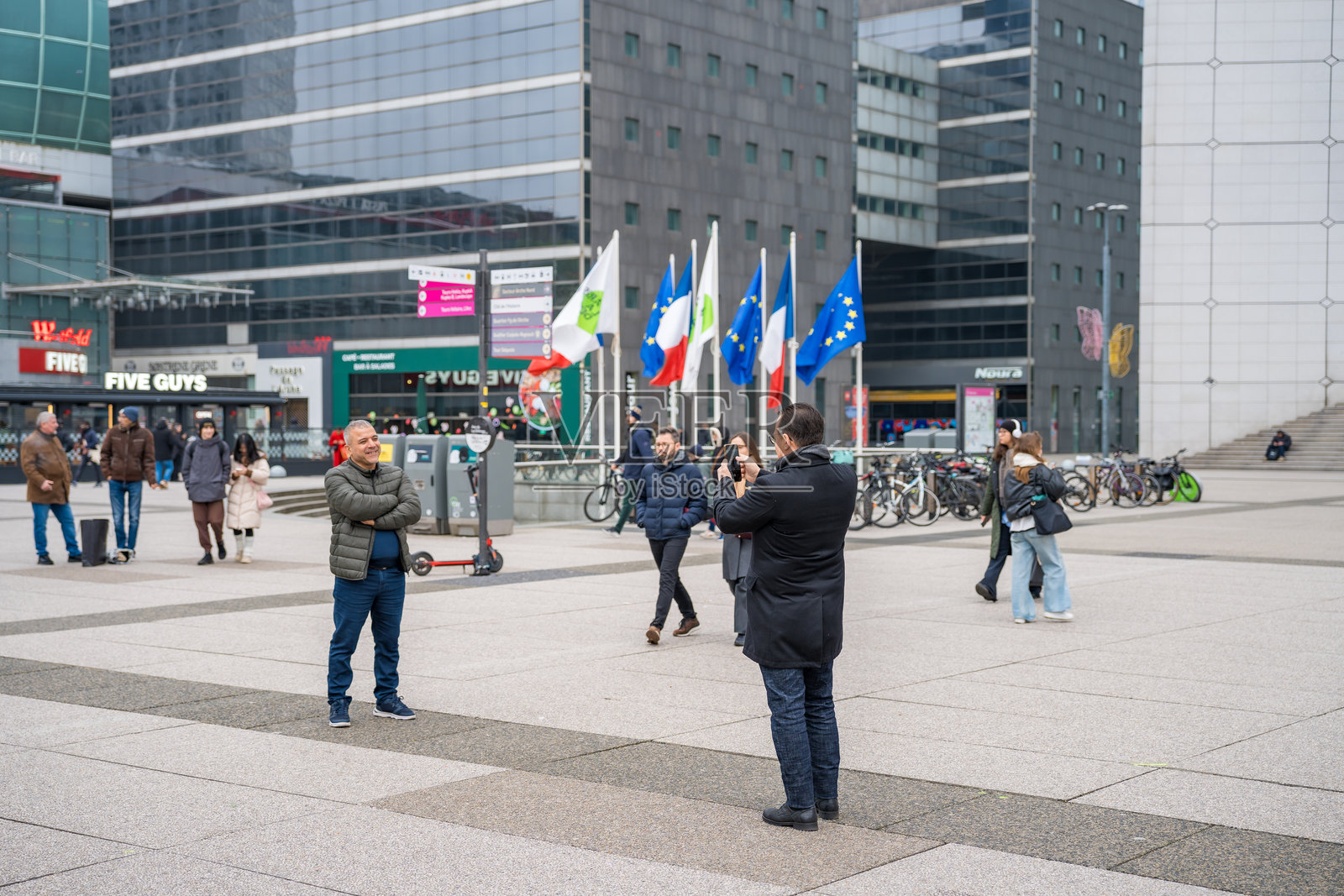 朋友们在热闹的城市广场上用国际旗帜捕捉回忆照片摄影图片