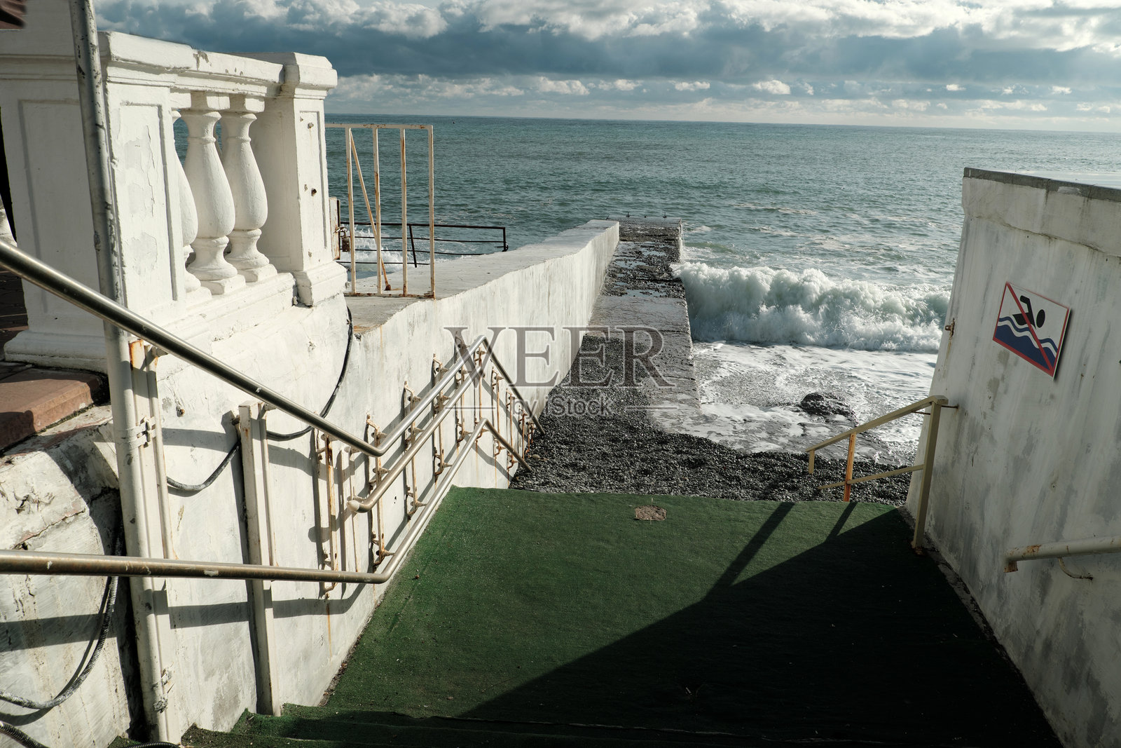 阳光明媚的码头上海面风暴。照片摄影图片