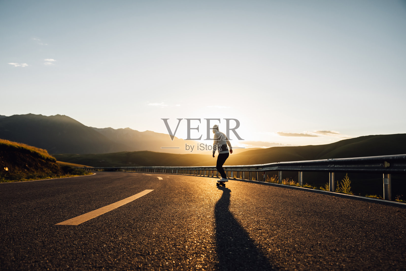 滑板运动员在山路上滑板照片摄影图片