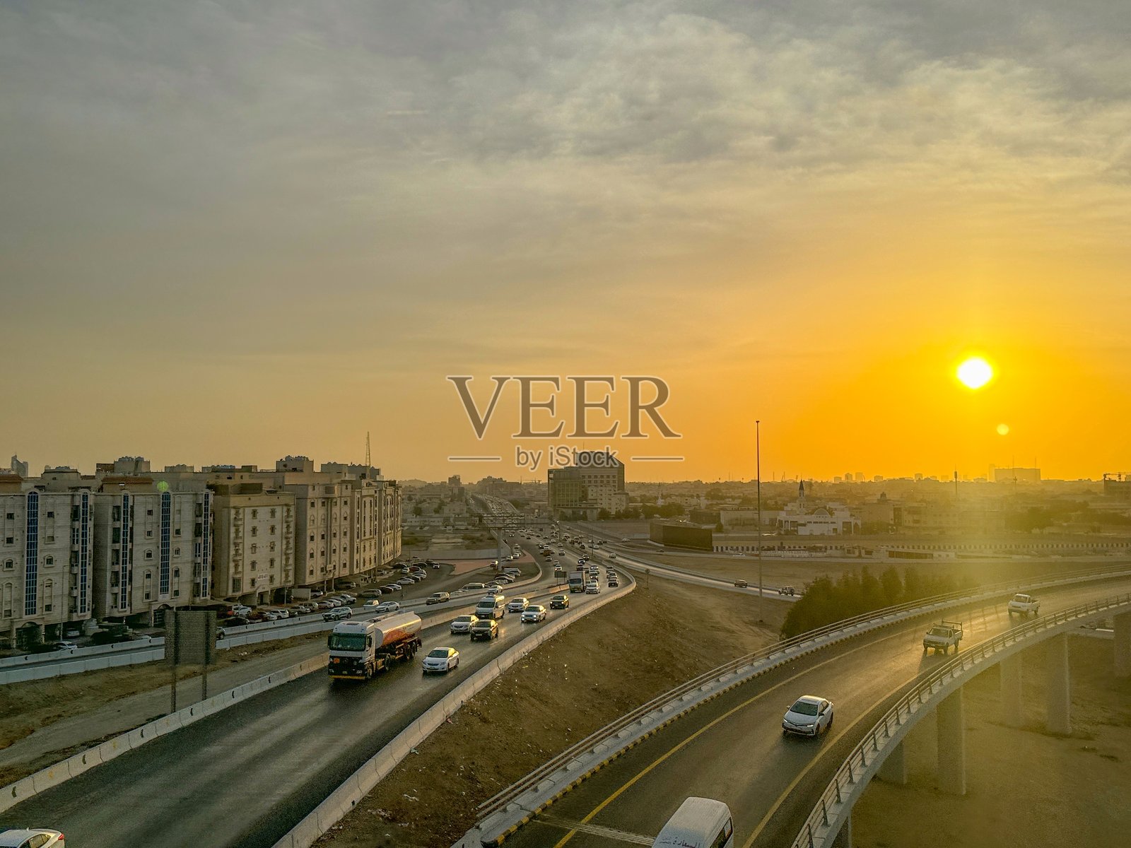 杰达下午的壮丽景色，城市天际线沐浴在温暖的金色阳光下。画面展现了现代摩天大楼与传统建筑的对比。照片摄影图片