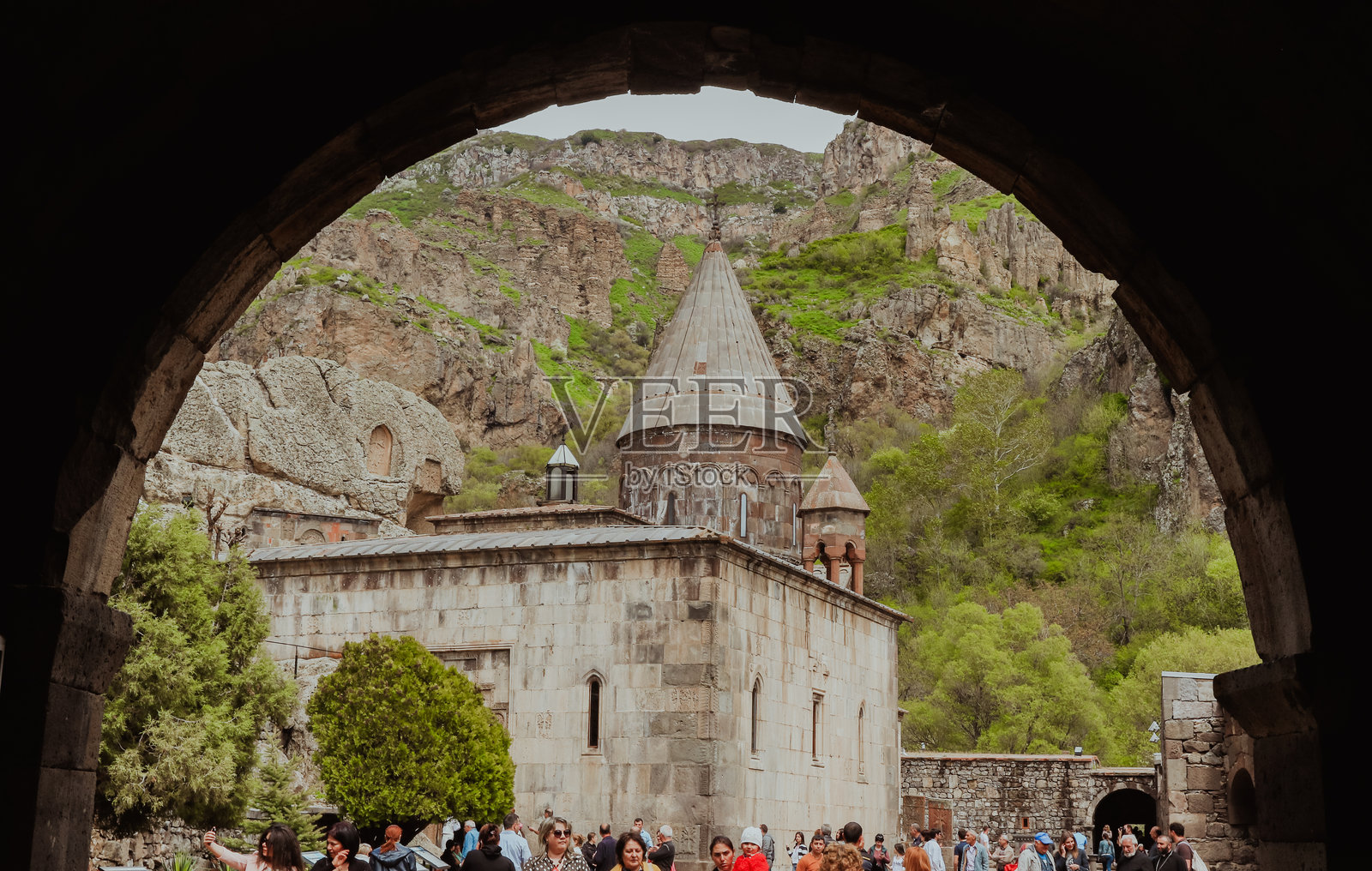 游客在亚美尼亚的盖加德修道院探索，周围是壮丽的山景照片摄影图片