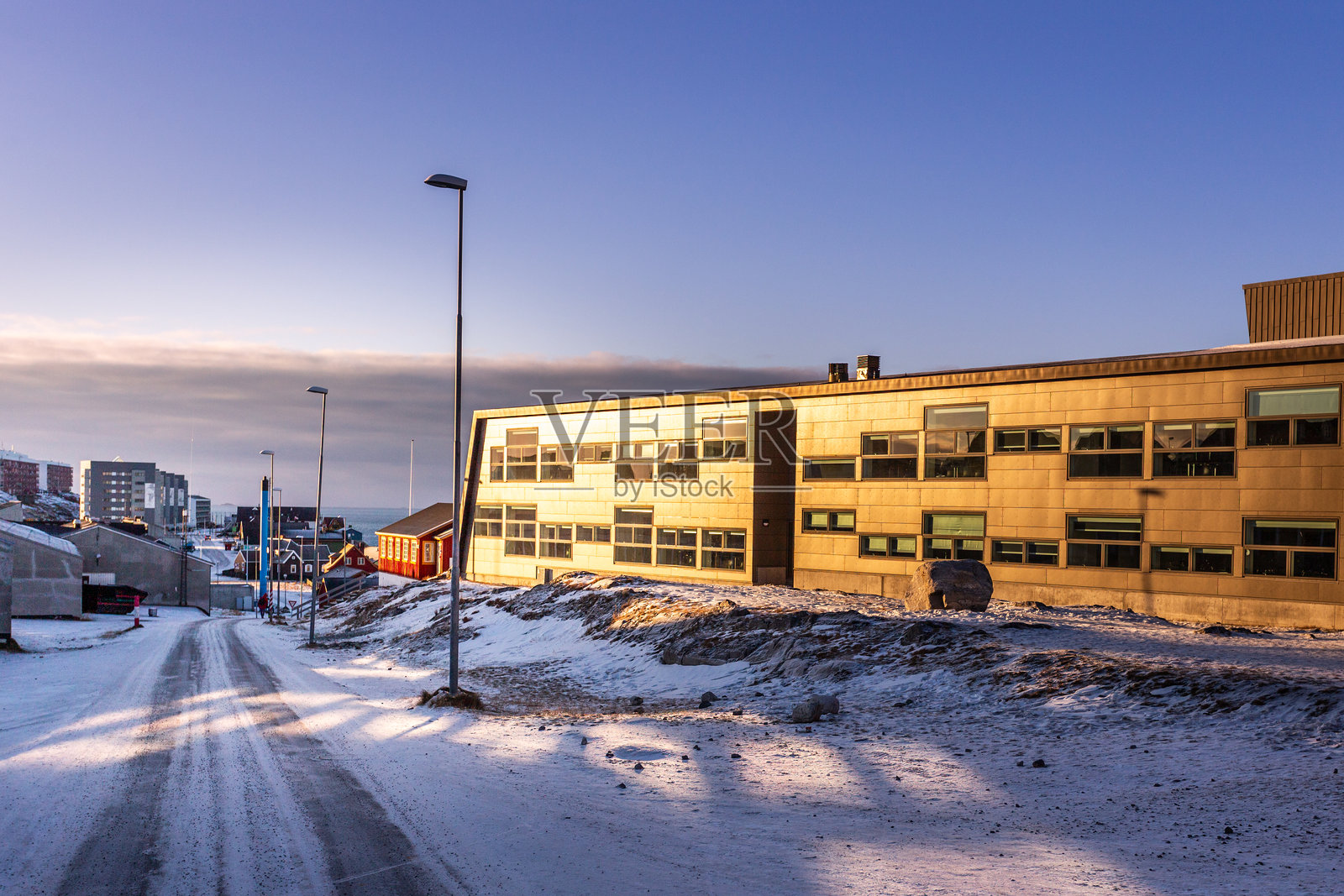 现代办公大楼反射着阳光，位于格林兰努克市被雪覆盖的街道上照片摄影图片