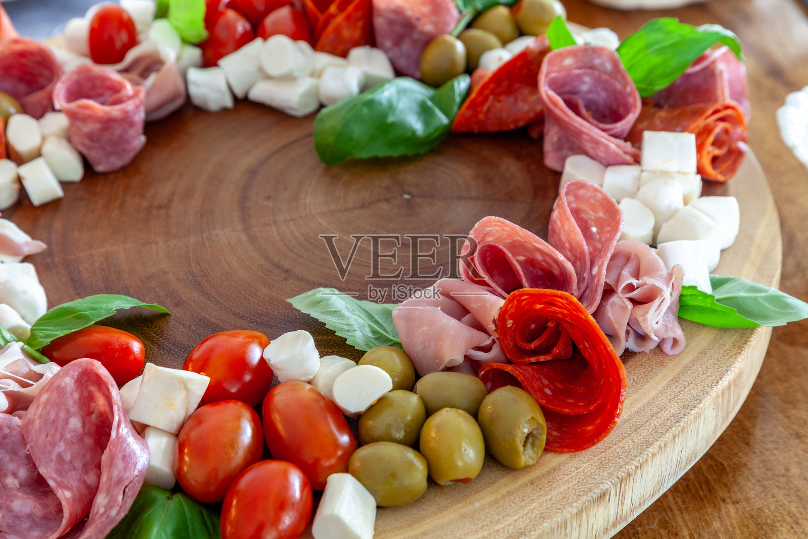 意大利香肠花环，配有火腿、马苏里拉奶酪、西红柿、罗勒、萨拉米香肠和橄榄照片摄影图片