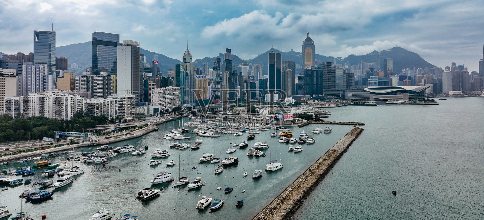 香港天际线的壮丽景色，港口有船只，背景是山脉。照片摄影图片
