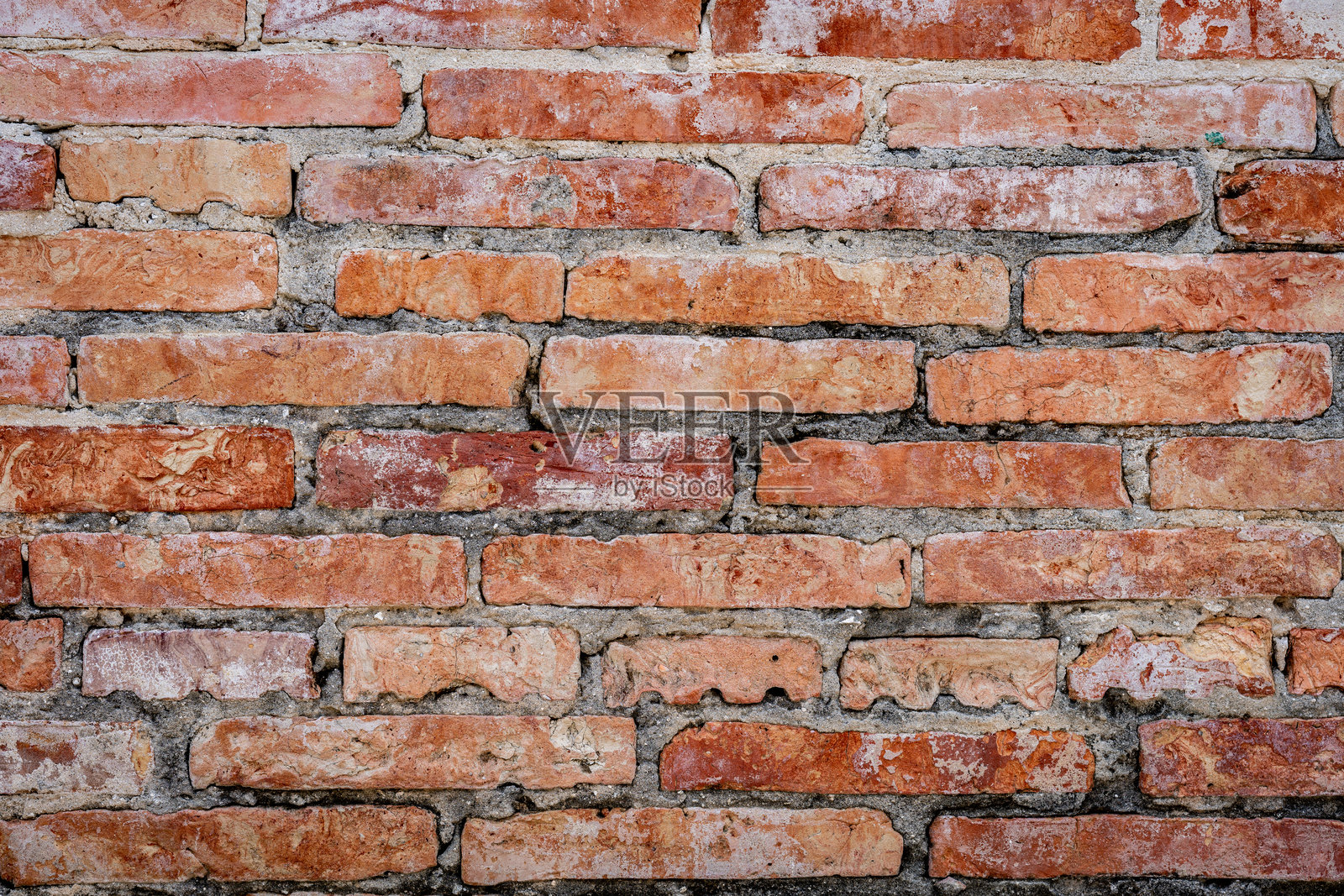 一堵风化的砖墙特写，显露出可见的砂浆和砖块颜色与质地的细微变化。图像传达出一种古老、历史和乡村魅力的感觉。照片摄影图片