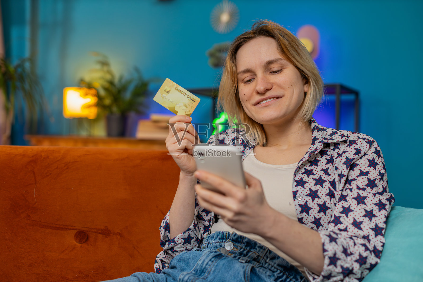 快乐的女性在网上商店进行在线购物支付，手持信用卡。照片摄影图片