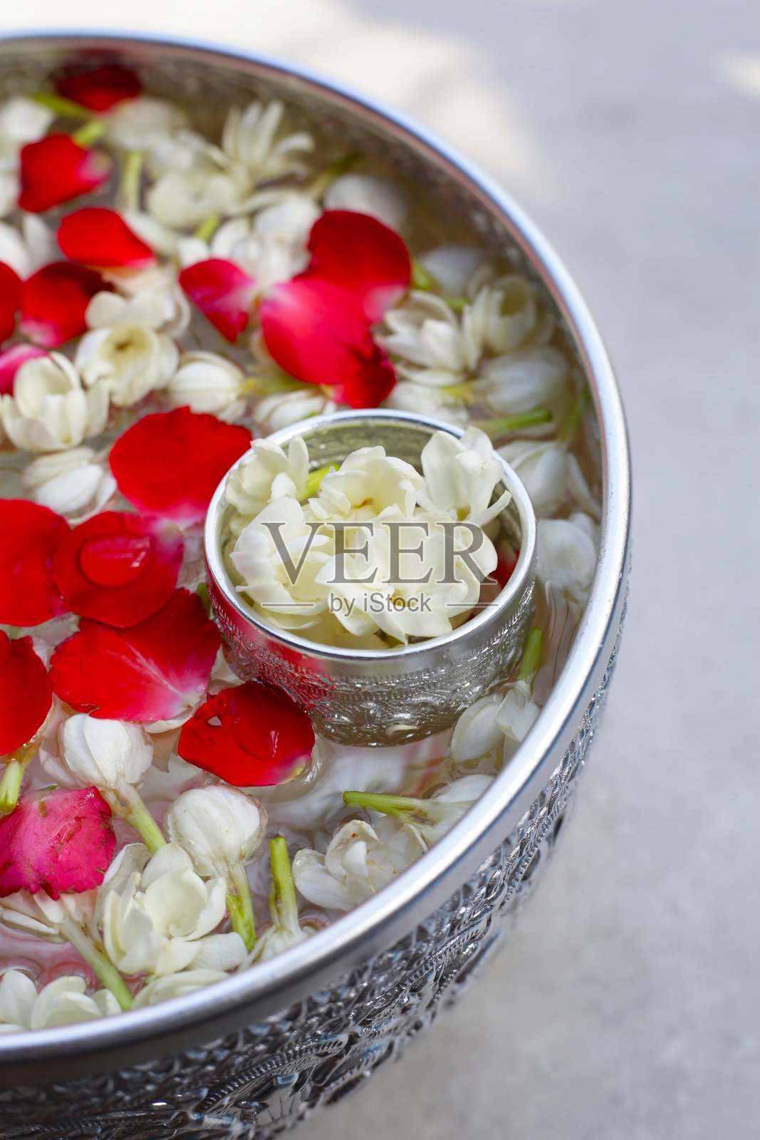 银碗中的茉莉花水与玫瑰花瓣。泰国传统，宋干节概念照片摄影图片
