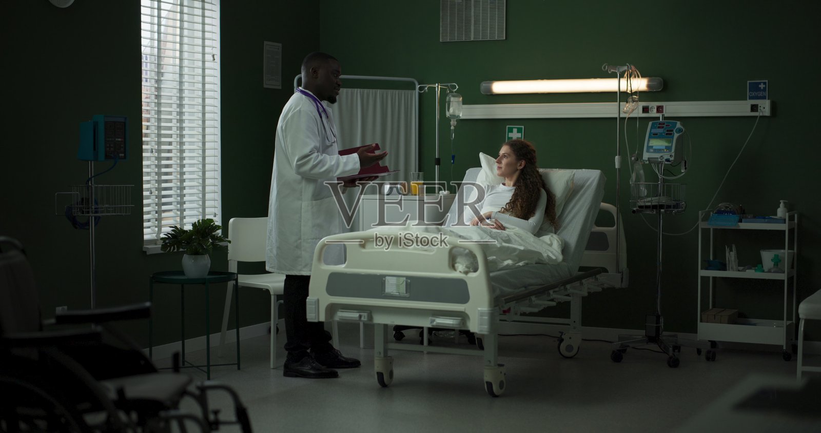 医生手持平板电脑拜访患者，讨论她的治疗方案照片摄影图片