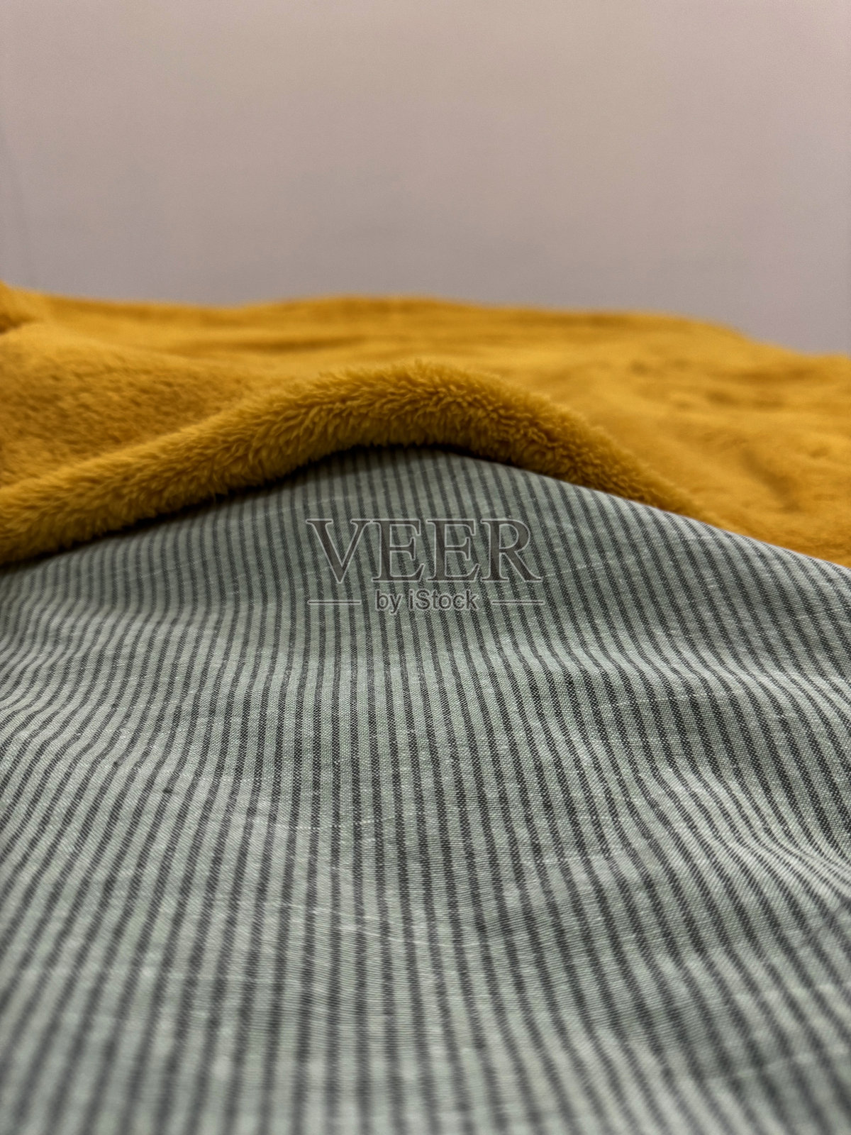 在温馨的室内环境中，柔和的灯光下展示的有纹理的织物层次照片摄影图片