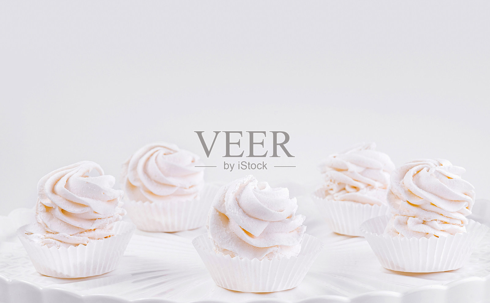 优雅的杯子蛋糕放在白色的高脚架上照片摄影图片