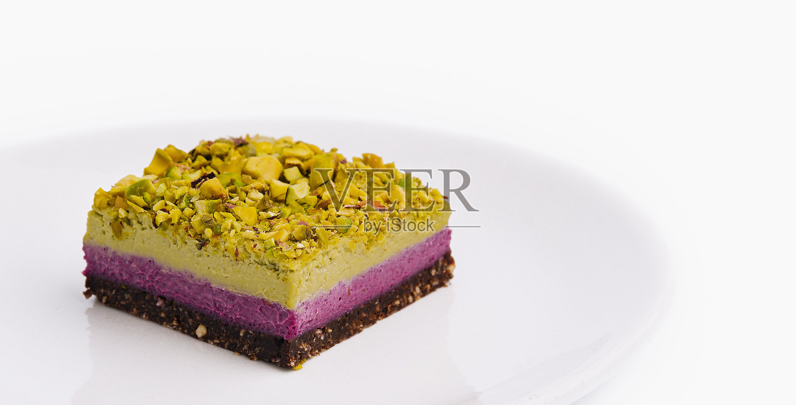 美味的开心果蛋糕切片，分层放在白色盘子上照片摄影图片