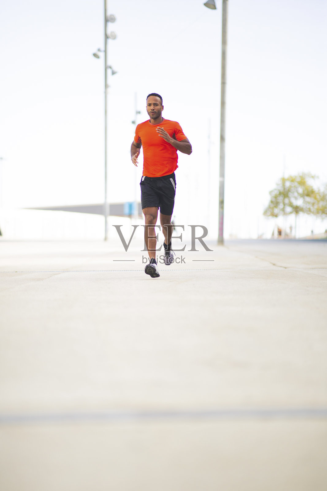 健身的非裔美国男性在城市中慢跑照片摄影图片