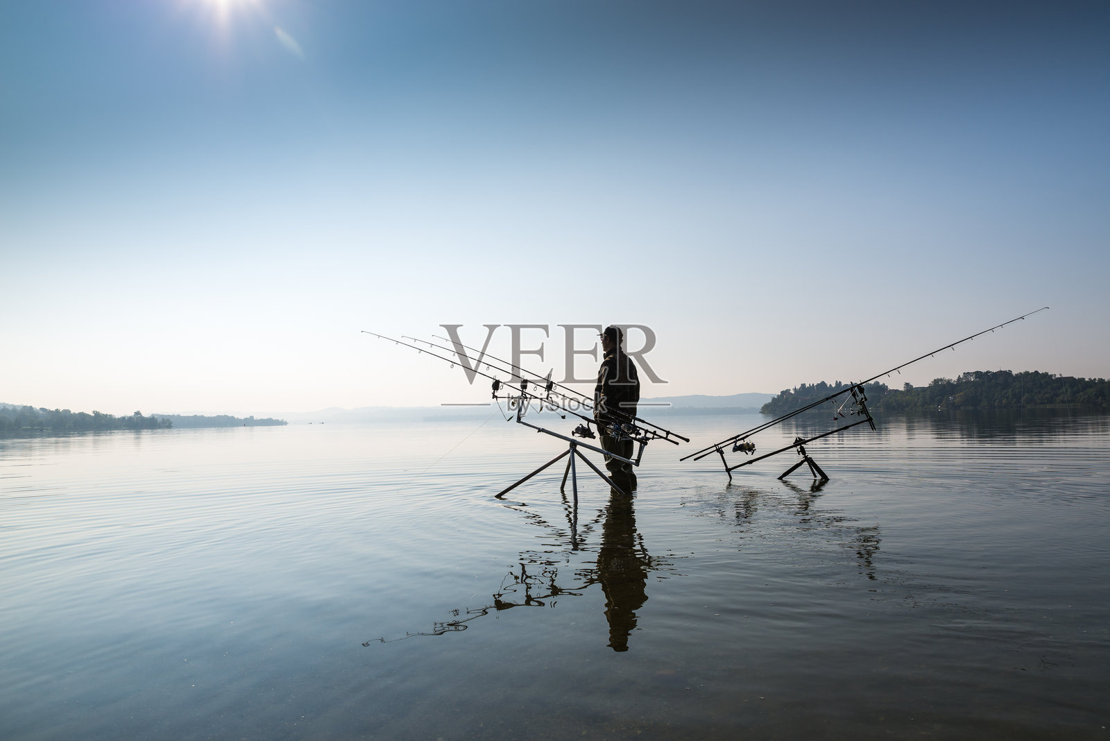 钓鱼冒险，鲤鱼钓鱼。水中的男人正在钓鱼。照片摄影图片